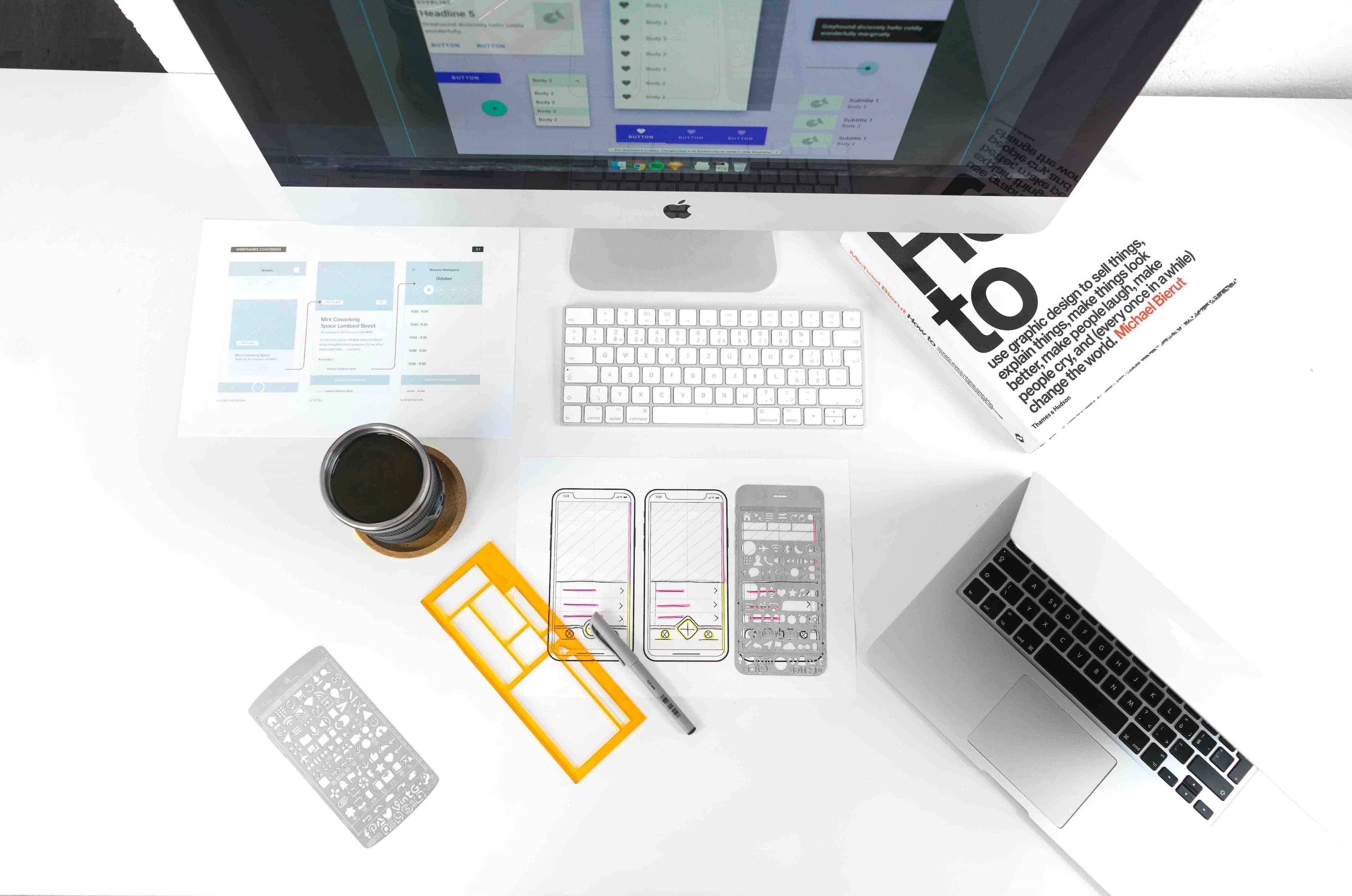 A laptop, a monitor and some design drawings